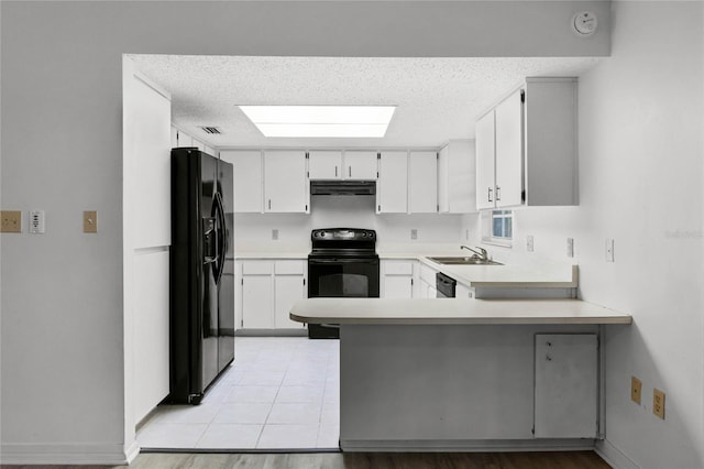 kitchen featuring sink, white cabinetry, a kitchen breakfast bar, kitchen peninsula, and black appliances