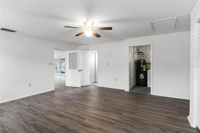 unfurnished room with washer / clothes dryer, dark wood-type flooring, water heater, and a textured ceiling