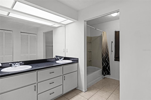 bathroom featuring shower / bath combo with shower curtain, vanity, tile patterned flooring, and a textured ceiling