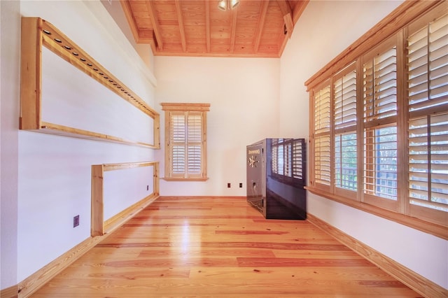 interior space with wood ceiling, light wood-type flooring, beamed ceiling, and a healthy amount of sunlight