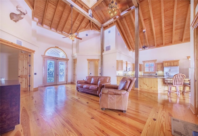 living room with wood ceiling, light wood-type flooring, beamed ceiling, high vaulted ceiling, and ceiling fan