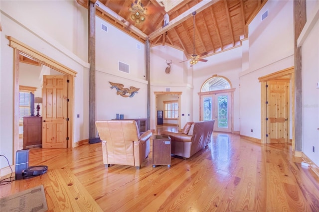 living room with high vaulted ceiling, beam ceiling, ceiling fan, and a healthy amount of sunlight