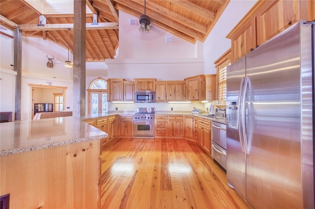 kitchen with hanging light fixtures, beam ceiling, stainless steel appliances, and high vaulted ceiling