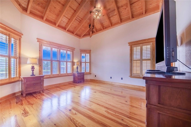 interior space featuring light hardwood / wood-style flooring, beam ceiling, high vaulted ceiling, and wooden ceiling