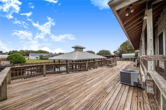 wooden terrace with a gazebo and central air condition unit