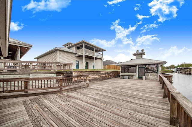 wooden terrace featuring a water view and a gazebo