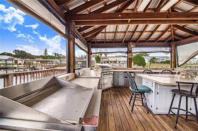 wooden terrace featuring a water view, area for grilling, and grilling area