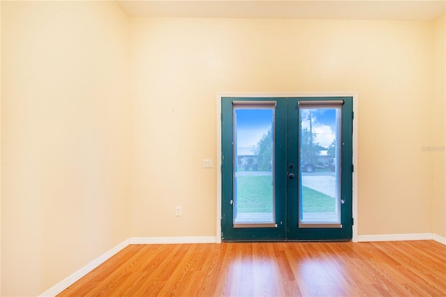 spare room featuring french doors and hardwood / wood-style flooring