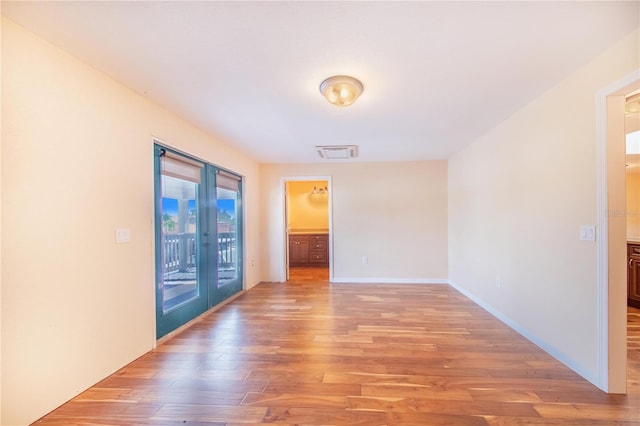 spare room featuring french doors and hardwood / wood-style flooring