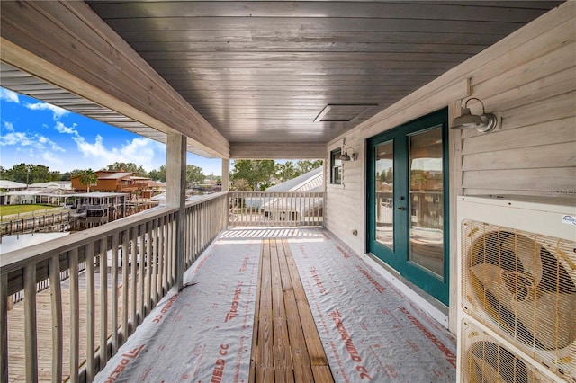 wooden terrace with ac unit and french doors