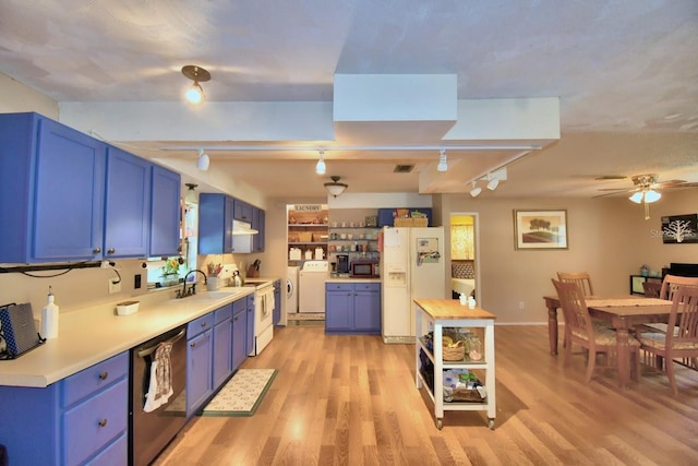 kitchen featuring white appliances, light hardwood / wood-style floors, blue cabinetry, and washer / clothes dryer