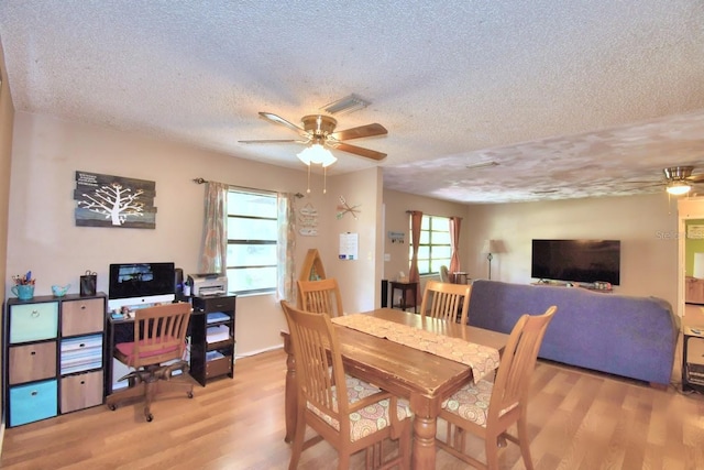 dining area with ceiling fan, light hardwood / wood-style flooring, and a healthy amount of sunlight