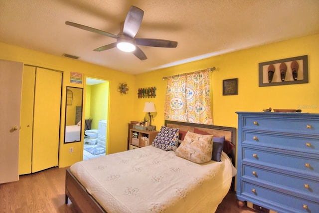 bedroom featuring a closet, ensuite bathroom, ceiling fan, and wood-type flooring