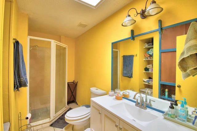 bathroom featuring tile patterned floors, toilet, vanity, and a shower with shower door