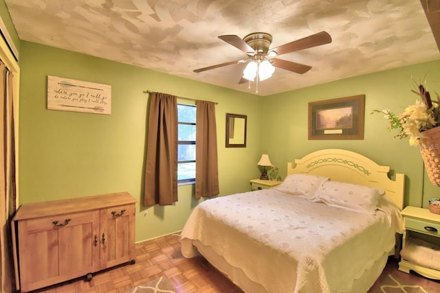 bedroom with ceiling fan, light parquet flooring, and a closet