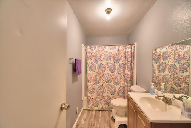 full bathroom featuring hardwood / wood-style floors, vanity, toilet, and shower / tub combo