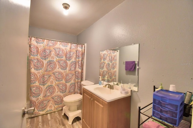 full bathroom featuring hardwood / wood-style flooring, vanity, toilet, and shower / tub combo