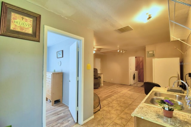 kitchen featuring sink, washer / dryer, and a textured ceiling