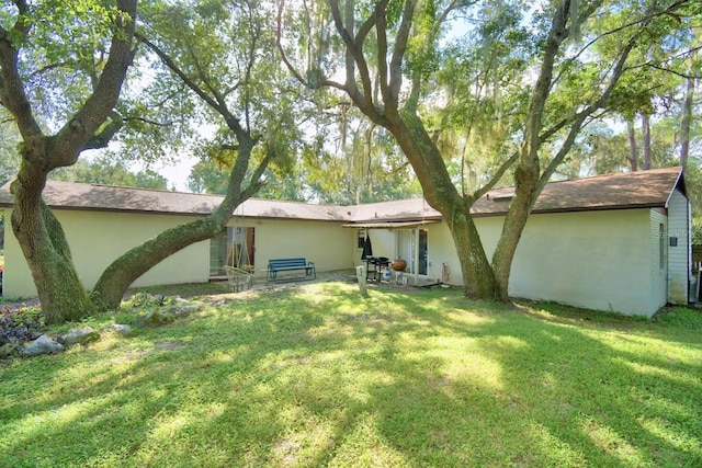 rear view of property with a yard and a patio area