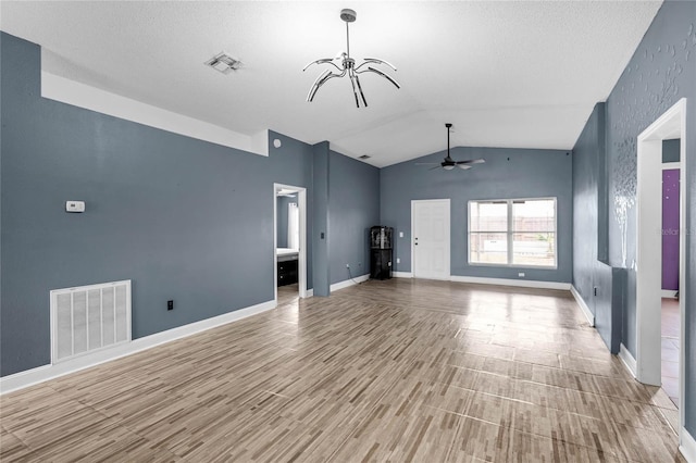 unfurnished living room featuring ceiling fan with notable chandelier, vaulted ceiling, and light hardwood / wood-style flooring