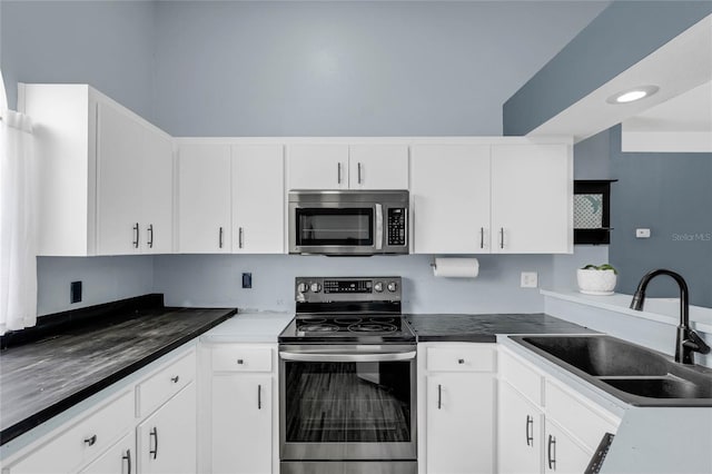 kitchen featuring appliances with stainless steel finishes, white cabinetry, and sink