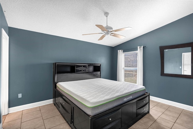 tiled bedroom featuring ceiling fan, a textured ceiling, and lofted ceiling