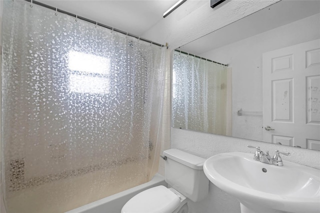 full bathroom featuring toilet, shower / bath combo with shower curtain, and sink