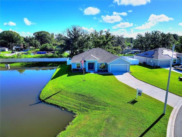 view of front facade featuring a front yard, a garage, and a water view