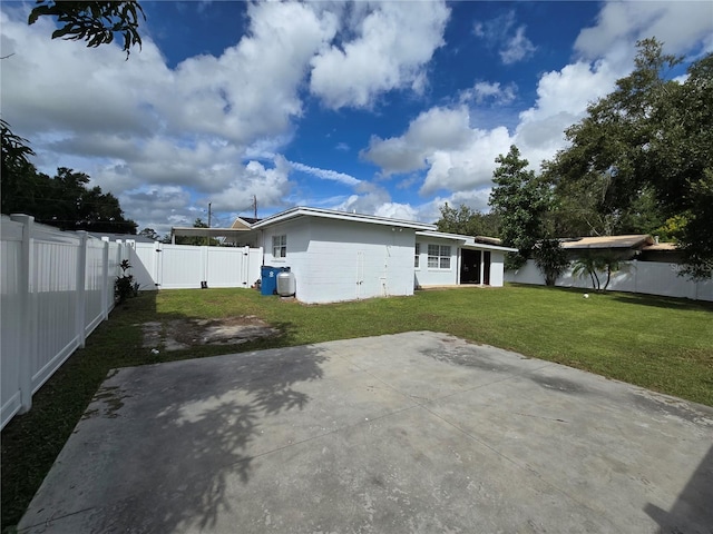 back of house featuring a patio area and a yard