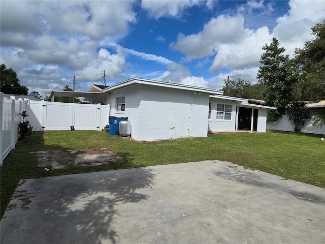 rear view of property with a patio and a yard