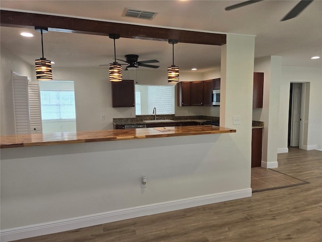 kitchen featuring wood-type flooring, pendant lighting, sink, and ceiling fan