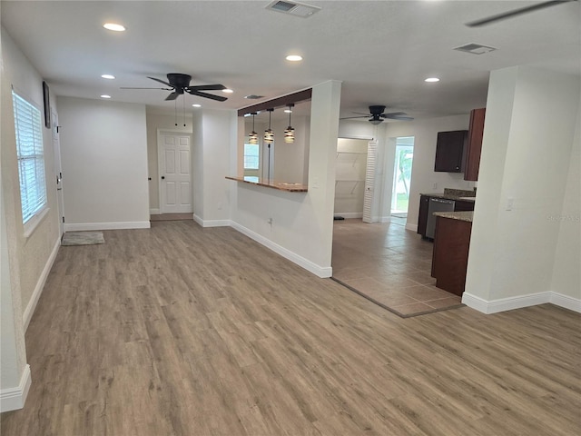 unfurnished living room featuring ceiling fan and light wood-type flooring