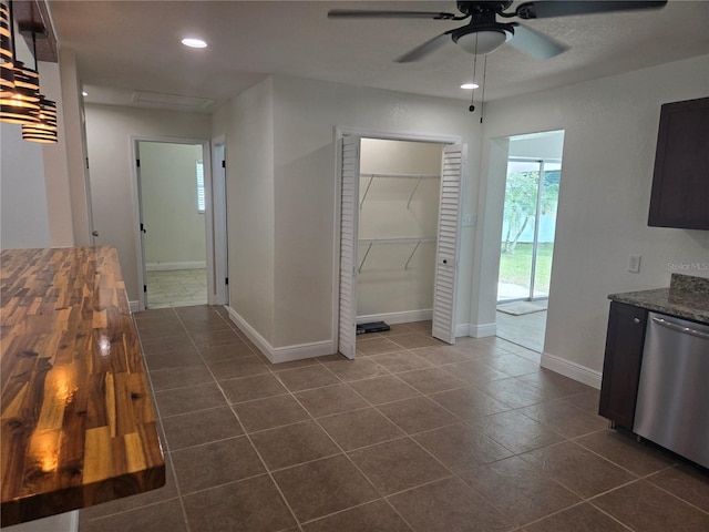 kitchen featuring ceiling fan, butcher block countertops, dishwasher, and dark tile patterned flooring