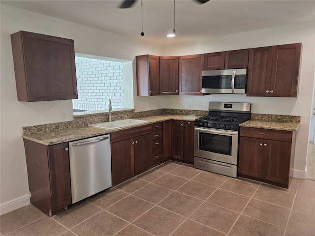 kitchen with appliances with stainless steel finishes, sink, ceiling fan, and dark tile patterned flooring