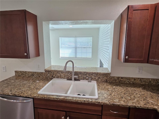 kitchen featuring dark stone counters, sink, and stainless steel dishwasher