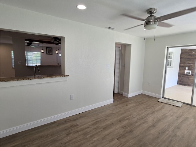 unfurnished living room featuring ceiling fan and hardwood / wood-style flooring