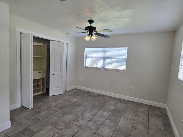 unfurnished bedroom featuring ceiling fan and a closet