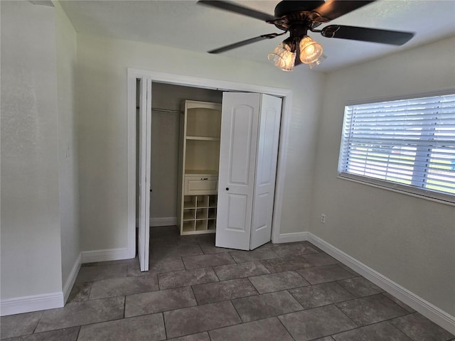 unfurnished bedroom featuring ceiling fan and a closet