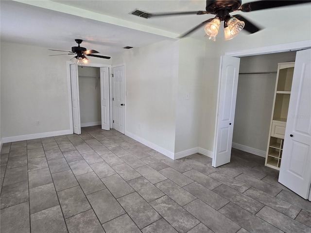 unfurnished bedroom with multiple closets and ceiling fan