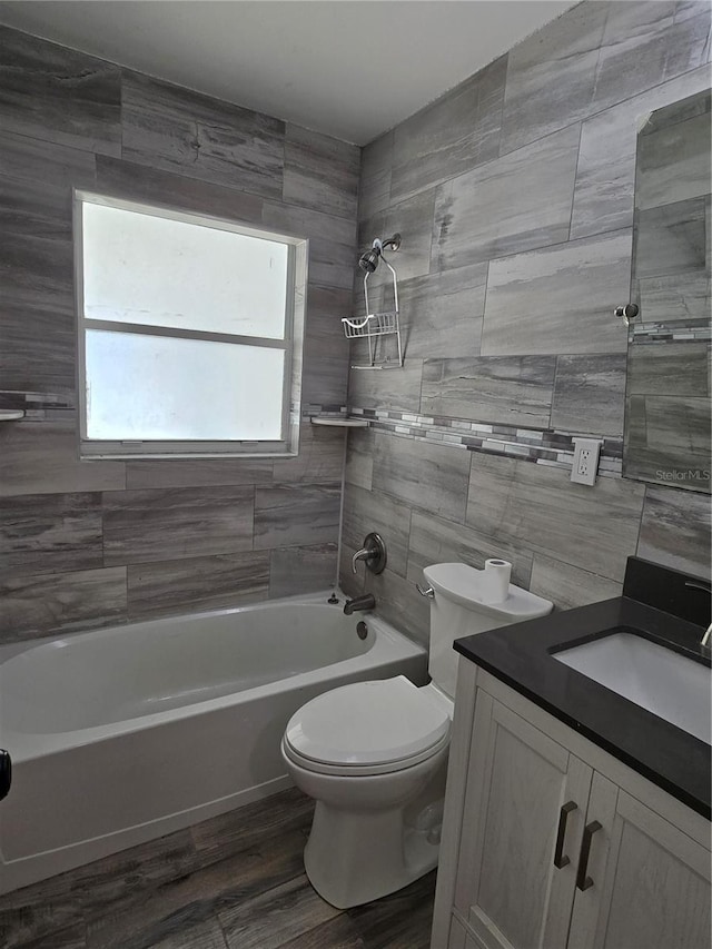 full bathroom with tiled shower / bath combo, vanity, toilet, and wood-type flooring