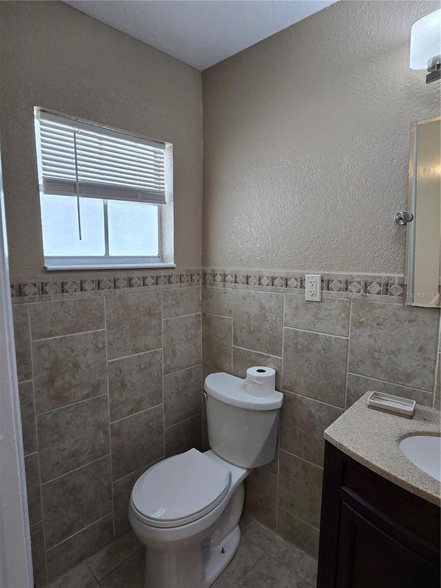 bathroom featuring tile walls, tile patterned flooring, vanity, and toilet