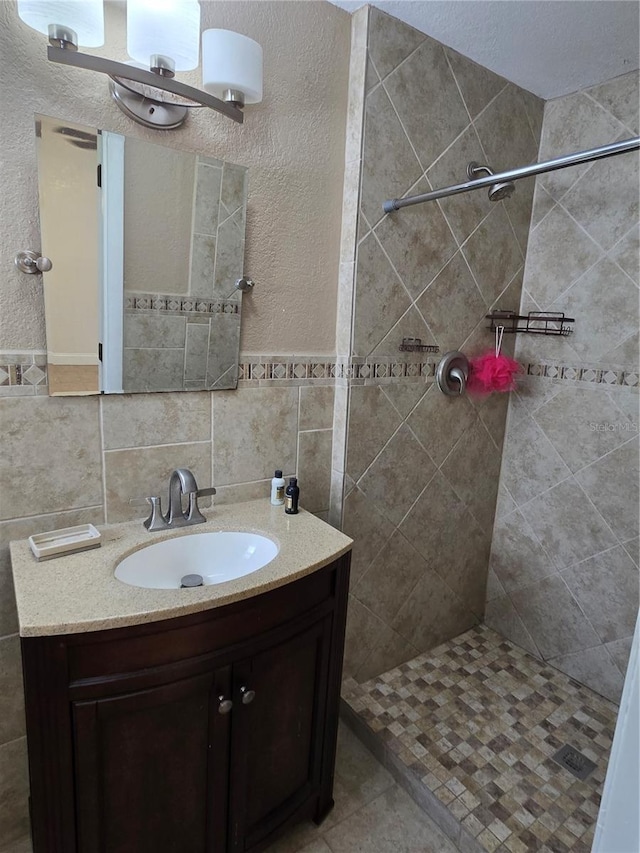 bathroom featuring vanity, tile walls, and a tile shower