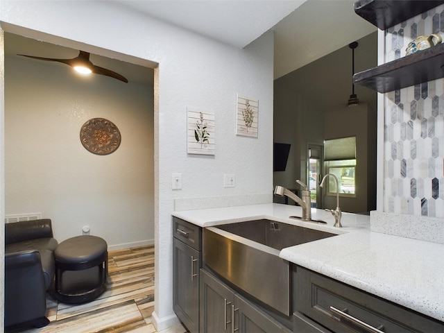 kitchen with ceiling fan, light hardwood / wood-style flooring, decorative light fixtures, dark brown cabinetry, and sink