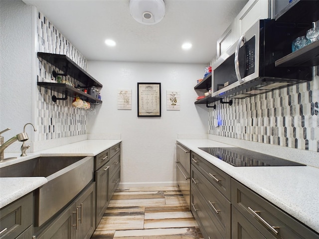 kitchen featuring dark brown cabinetry, black electric stovetop, and tasteful backsplash