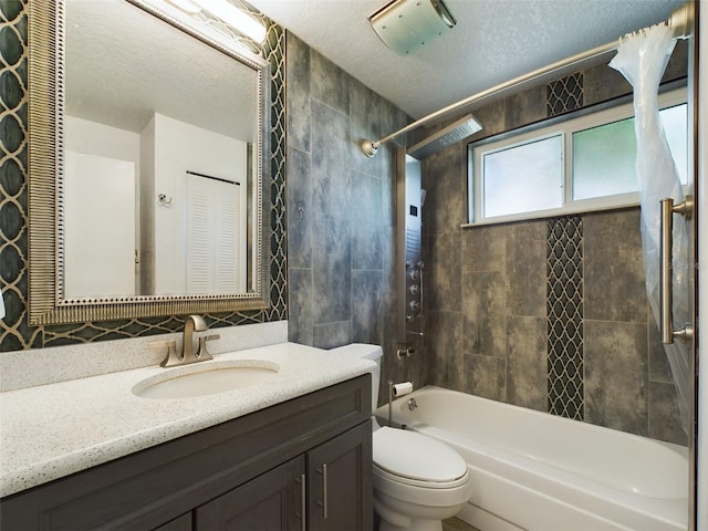 full bathroom featuring vanity, tiled shower / bath combo, toilet, and a textured ceiling