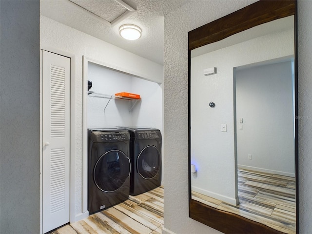 washroom featuring a textured ceiling, separate washer and dryer, and hardwood / wood-style floors