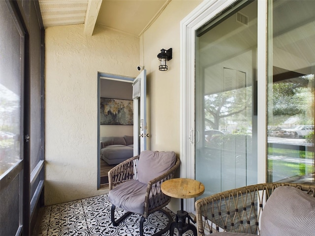 sunroom / solarium featuring vaulted ceiling with beams