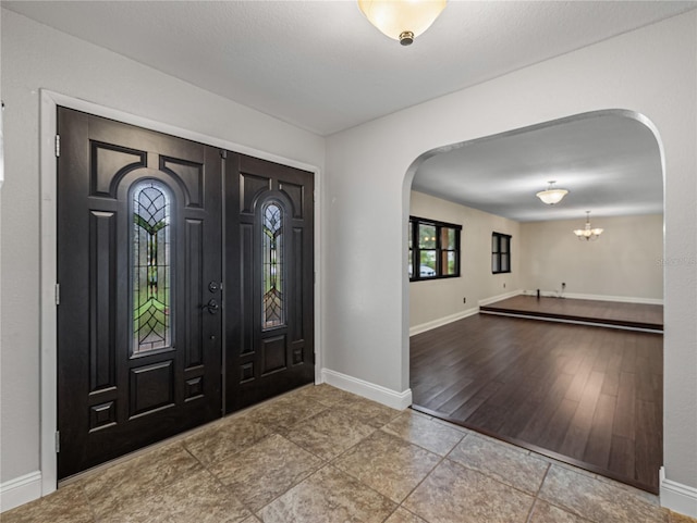 foyer with hardwood / wood-style flooring and a notable chandelier