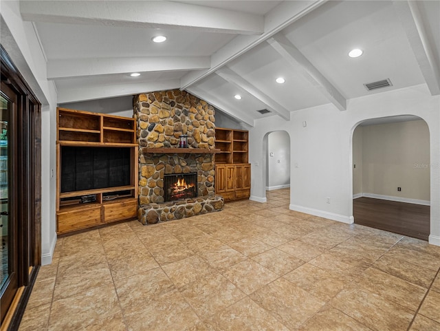 unfurnished living room with a fireplace, lofted ceiling with beams, and built in features