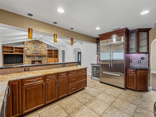 kitchen with hanging light fixtures, appliances with stainless steel finishes, built in features, and lofted ceiling